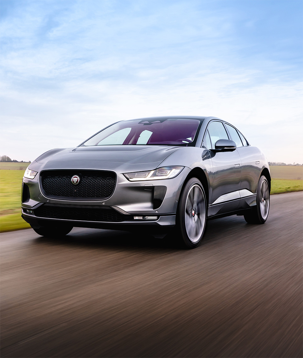 Front view of Jaguar driving down the road